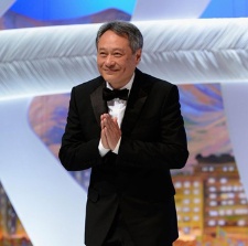 李安西装登台笑容满面 双手合十祈福尽显谦和