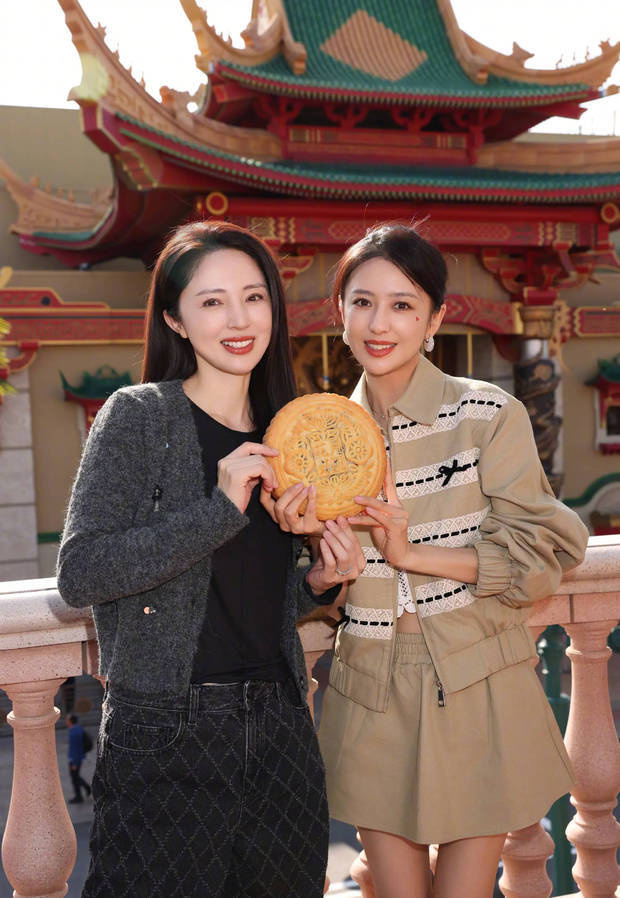 董璇与佟丽娅拿着大月饼拍照,笑容甜美迷人。