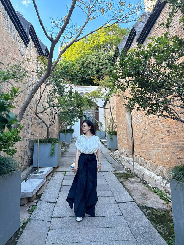 陈数悠闲地走在小巷子里,欣赏城市美景。