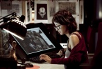 李诗英眼戴黑框眼镜，巧露香肩，盯着电脑屏幕研究案情。