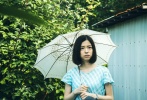木下美咲饰演的少女在细雨中撑着伞。