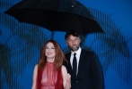 威尼斯电影节艺术总监为摩尔撑伞，并与摩尔亲密合影。