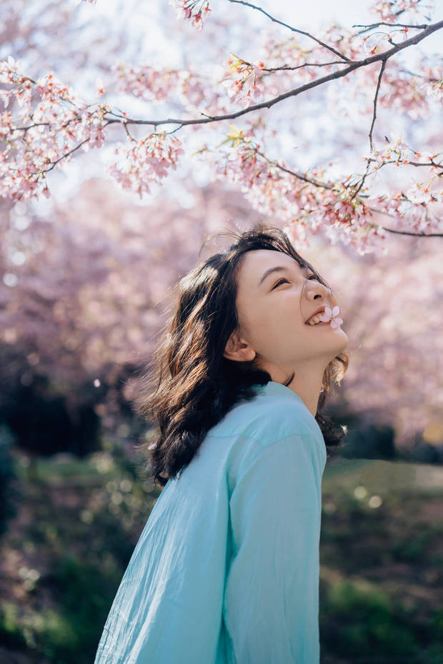 搜狐娛樂訊 3月26日，吳倩時隔十年重回武漢櫻海，身穿藍色連衣裙，與櫻花的粉色完美融合，笑起來甜美可愛，少女感十足。