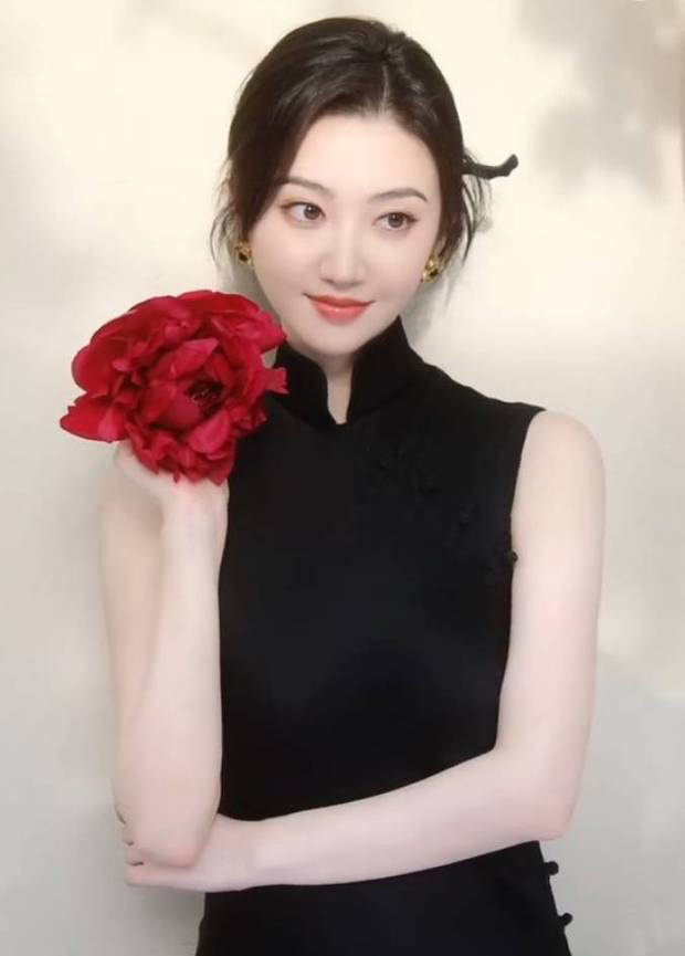 景甜手拿大紅花拍照。