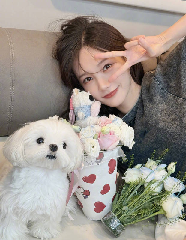 李一桐抱著花和小狗合影。