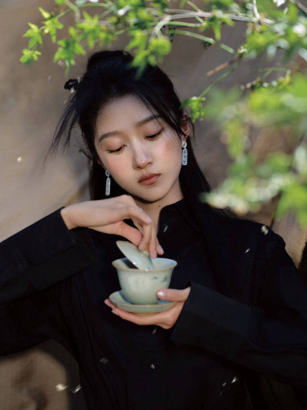 關(guān)曉彤手掀茶蓋，神態(tài)專注。
